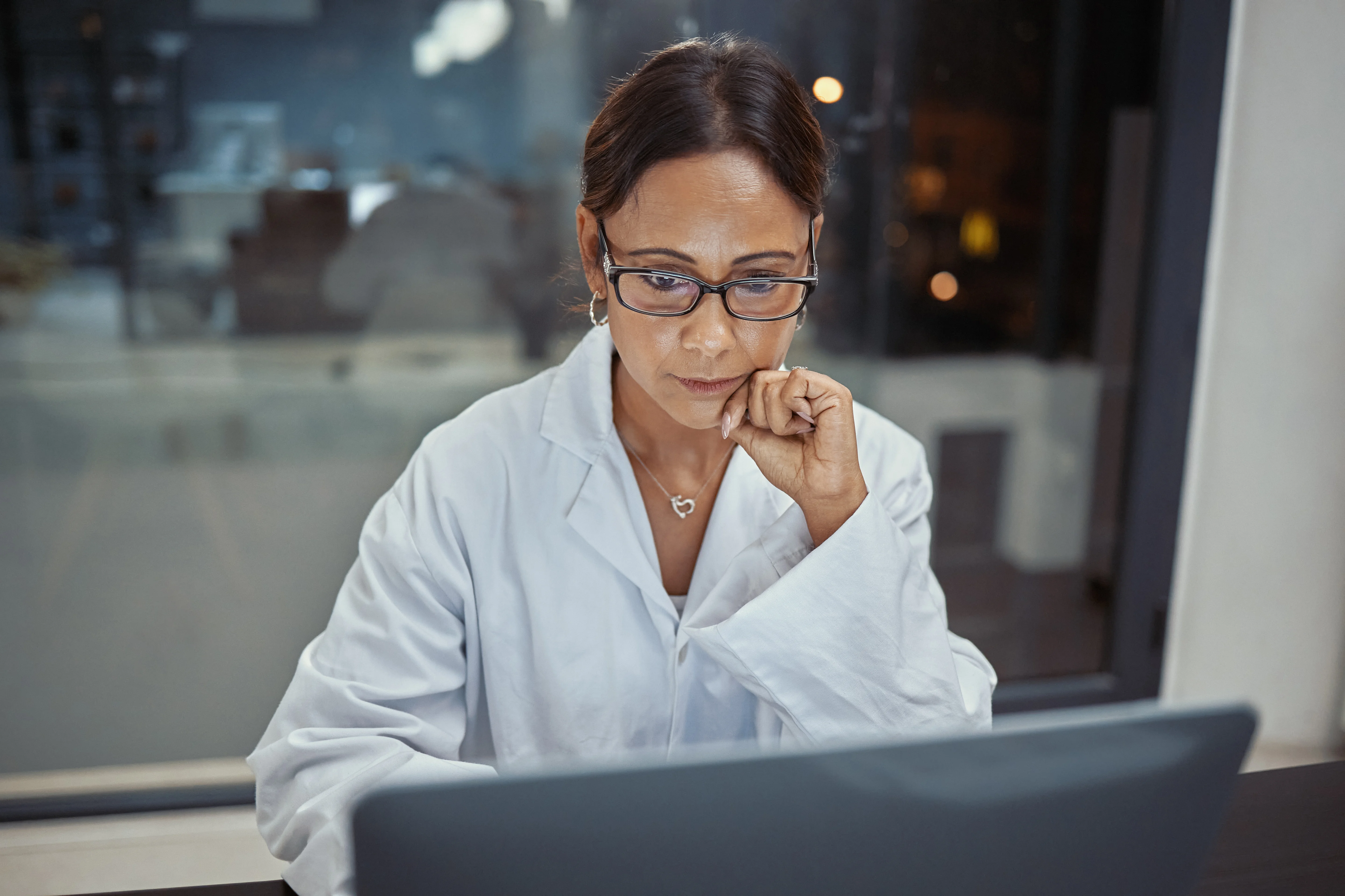 A scientist working on a laptop in a lab.